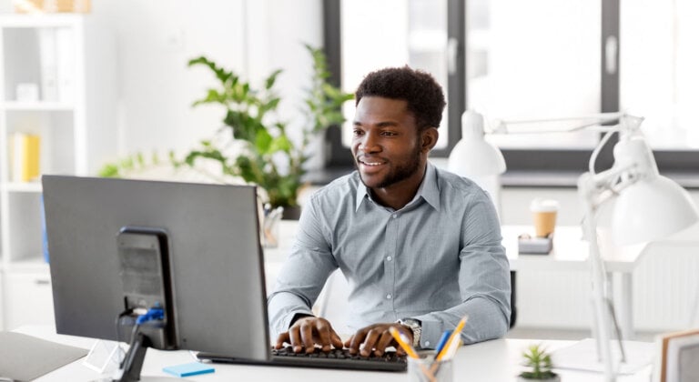 Man smiling in front of computer