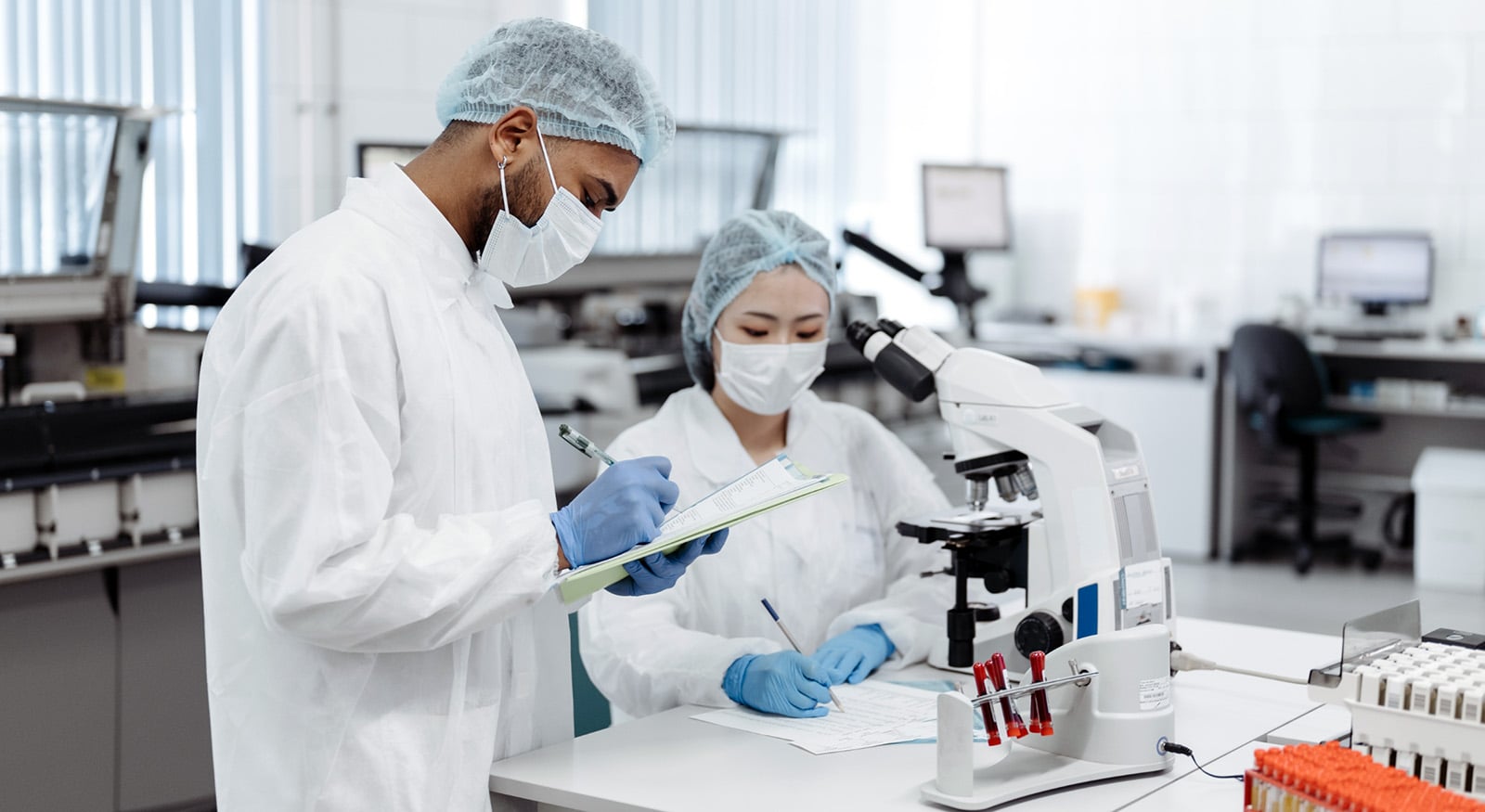 Two people in lab coats working in lab